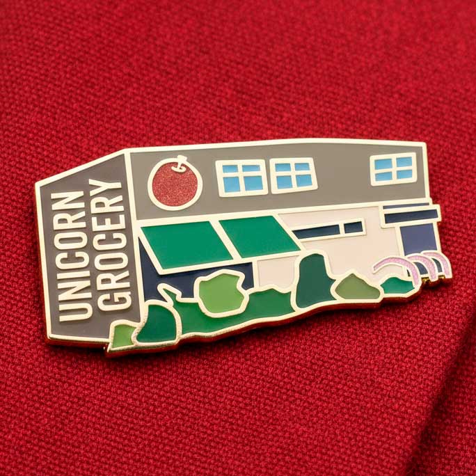 Shop front enamel pin badges for Unicorn Grocery food co-op in Chorlton Manchester by Paper Rhino design