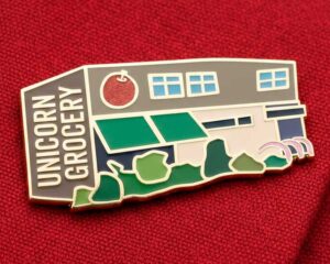 Shop front enamel pin badges for Unicorn Grocery food co-op in Chorlton Manchester by Paper Rhino design